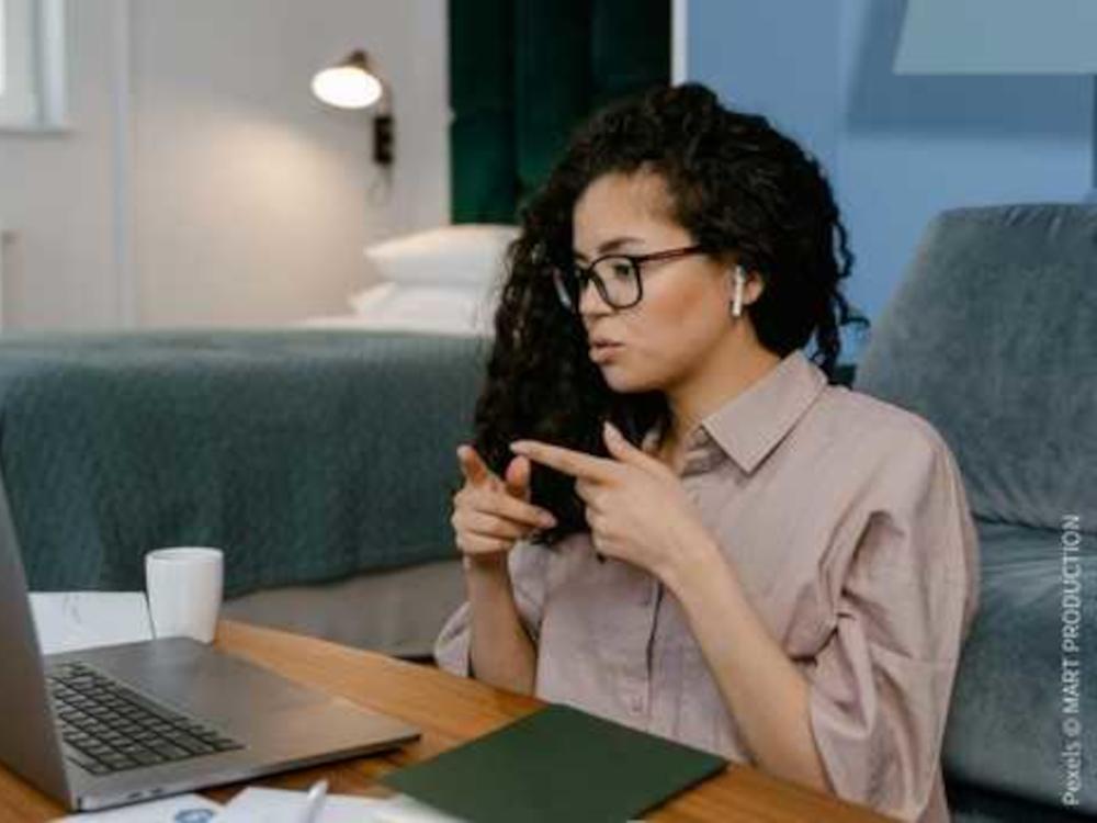 Person sitzt vor einem Laptop