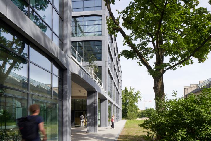 Ansicht des Munich Urban Colab schräg von außen mit einem Baum rechts