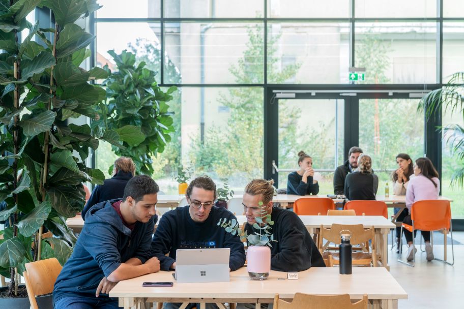 Junge Menschen sitzen in der Cafeteria des Munich Urban Colab