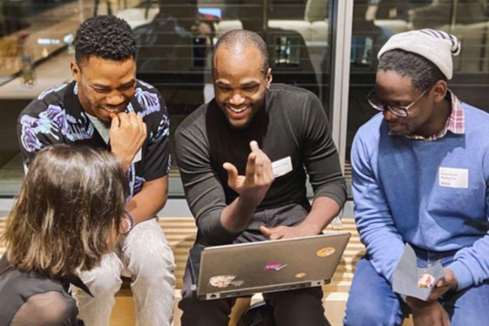 Vier Studierende mit Notebook im Gespräch