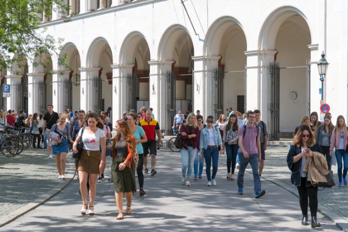 Studierende kommen aus dem LMU Hauptgebäude und überqueren den Geschwister Scholl Platz