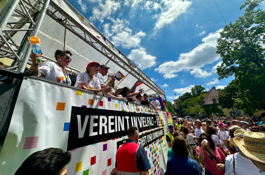 Personen auf einem Lastkraftwagen mit dem Motto "Vereint in Vielfalt" bei der PolitParade des Christopher Street Day 2025