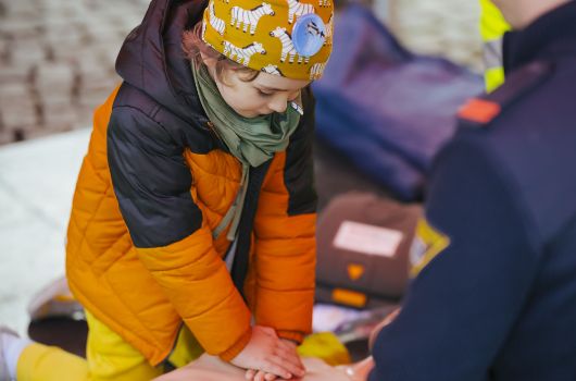 Kind an Herzmassagetrainingspuppe