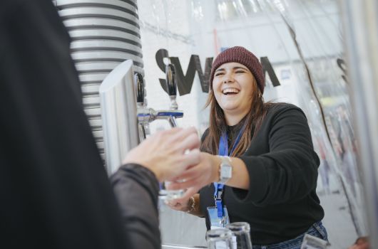 An der SWM-Wasserbar: Junge Frau gibt ein Glas Wasser aus