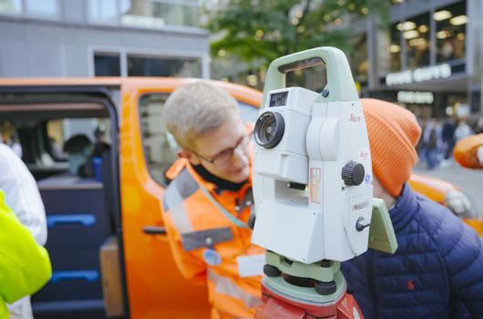 Junge und Vermessungsingenieur an einem Winkelmessgerät