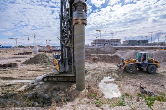 Bohrgerät. Im Hintergrund ist die Baustelle des Schulstandortes Bayernkaserne Süd zu sehen.