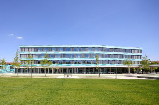 Blick in Richtung Norden auf die 4-geschossige Schule vom Rasenspielfeld