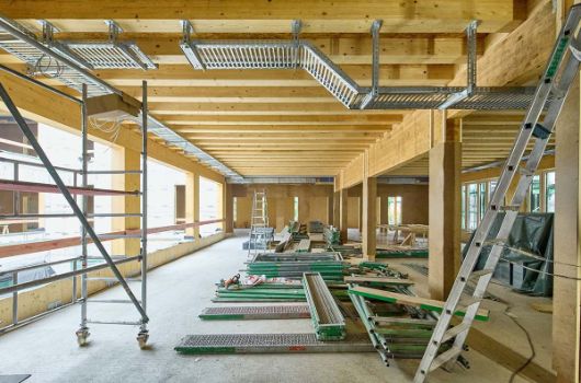 Zukünftiger Garderobenbereich eines Lernhauses mit Blick zum Lichthof, die Montage der ersten Elektrokabeltrassen hat begonnen