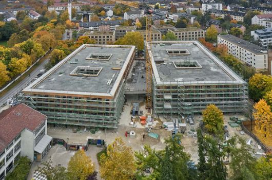 Blick von Westen über die Baustelle, die Fassadengerüste werden für den beginnenden Einbau der Fenster aufgestellt