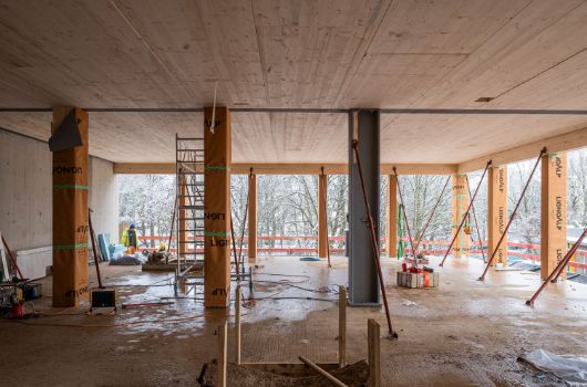 Im Inneren prägen bereits Holzstützen die künftigen Lernräume des nachhaltigen Holzhybridgebäudes.
