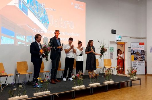 10 Jahre Berufsschule zur Berufsintegration - Buehne mit Herrn Kraus, Frau Dietl und Schüler*innen 