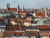 Panoramablick über die Dächer der Münchner Altstadt mit Frauenkirche, Altem Peter und dem Neuen Rathaus im Hintergrund.