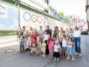 Auf dem Bild stehen die Kinder, Erzieherinnen mit Barbara Likus und Florian Kraus vor den neu verzierten Lärmschutzwänden im Marienhof.
