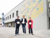 Drei Personen stehen mit Bällen vor dem neuen Betriebsgebäude der Sportanlage Siegenburger Straße.