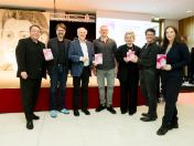 von links nach rechts: Peter Scheifele (Stadtdirektor), Florian Kraus (Stadtschulrat), Axel Selbert (Enkel von Dr. Elisabeth Selbert), Alexander Auner (Lehrkraft Münchner Farbe Schulen), Susanne Selbert (Enkelin Dr. Elisabeth Selbert), Mo Lüttig (Mitglied des Stadtrats) und Nicole Lassal (Städtische Gleichstellungsbeauftragte) stehen im Städtischen Elisabeth-Selbert-Bildungszentrum für Erziehungsberufe und lächeln in die Kamera.