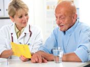 Ärztin zeigt Senior den Impfpass