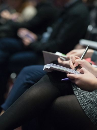Menschen in einem Gremium schreiben Notizen mit