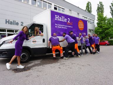 Personen schieben den Lieferwagen der Halle 2 an
