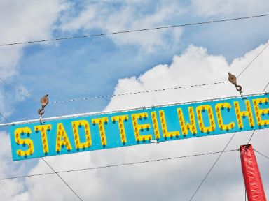 Das Foto zeigt die Leuchtreklame "Stadtteilwoche" auf dem Zirkuszelt